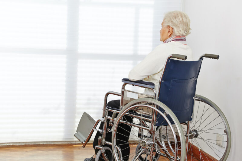 Lonely senior citizen woman in wheelchair in a nursing home